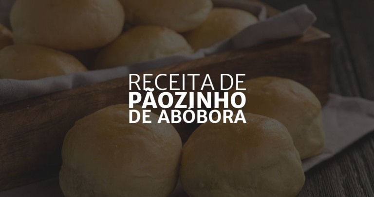 ao fundo a imagem de pãezinhos redondos e pequenos de abóbora, alguns estão dentro de uma travessa de madeira que tem um pano branco dentro e outros estão sobre a mesa, por cima um sombreado que dá destaque onde se lê "Receita de Pãozinho de Abóbora"