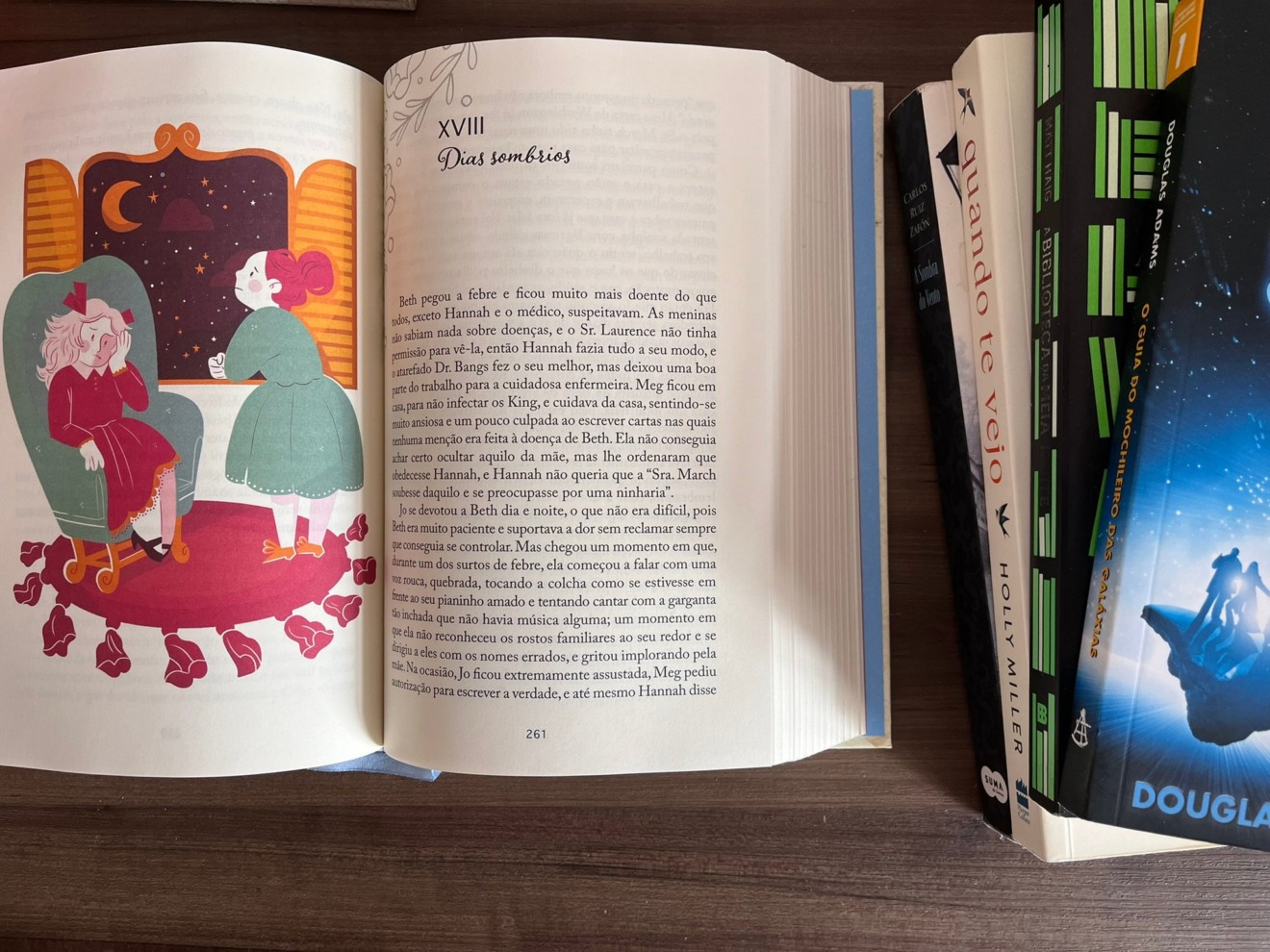 Livro "Mulherzinhas", de Louisa May Alcott, está aberto em cima de uma mesa na página 261, onde começa o capítulo 18, "Dias Sombrios"