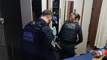 Dois agentes da Polícia Civil dentro de uma residência durante a operação Vindicare