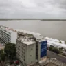 Vista do Centro Histórico de Porto Alegre, com a Avenida Sete de Setembro à esquerda e Mauá à direita, sob um céu nublado. Ao fundo, o Guaíba e suas ilhas.