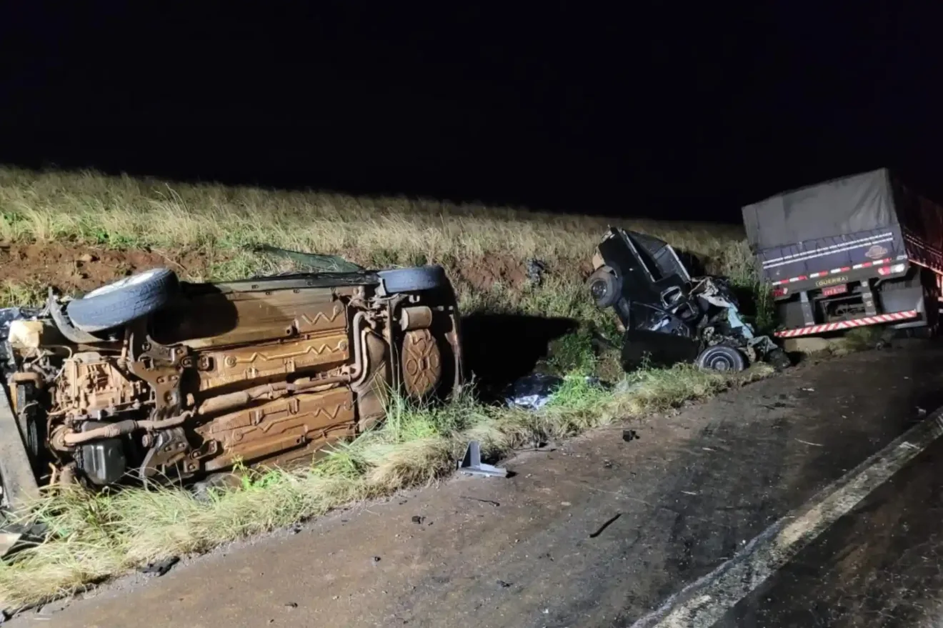 Imagem de um acidente de trânsito com veículos capotados na estrada ERS-322 à noite. Eles estão rodeados por grama.