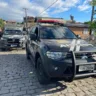 Carros da Polícia Civil do RS estacionados em uma rua de paralelepípedos, com agentes da polícia próximos.