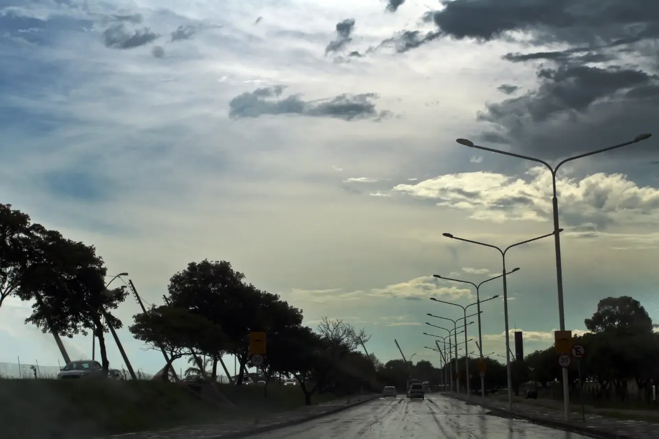 Vista da avenida Edvaldo Pereira Paiva molhada após chuva com carros, árvores ao lado e céu nublado.