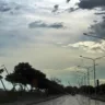 Vista da avenida Edvaldo Pereira Paiva molhada após chuva com carros, árvores ao lado e céu nublado.