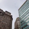 Vista do Centro de Porto Alegre em um dia nublado, com edifícios históricos e modernos, incluindo detalhes de janelas e uma palmeira.