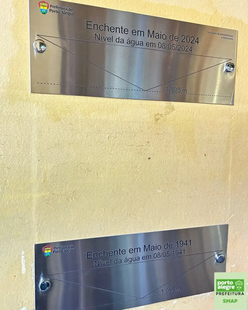 Placas de nível da água das enchentes em Porto Alegre, mostrando dados de 1941 e 2024.