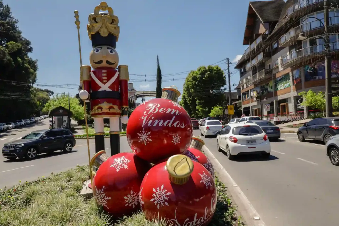 Decoração natalina com um boneco de madeira e enfeites vermelhos de Natal, mostrando uma calorosa recepção com a mensagem 'Bem Vindos'.