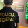 Membro da Polícia Federal em um ambiente institucional, mostrando a camisa com a inscrição 'Polícia Federal' em destaque.