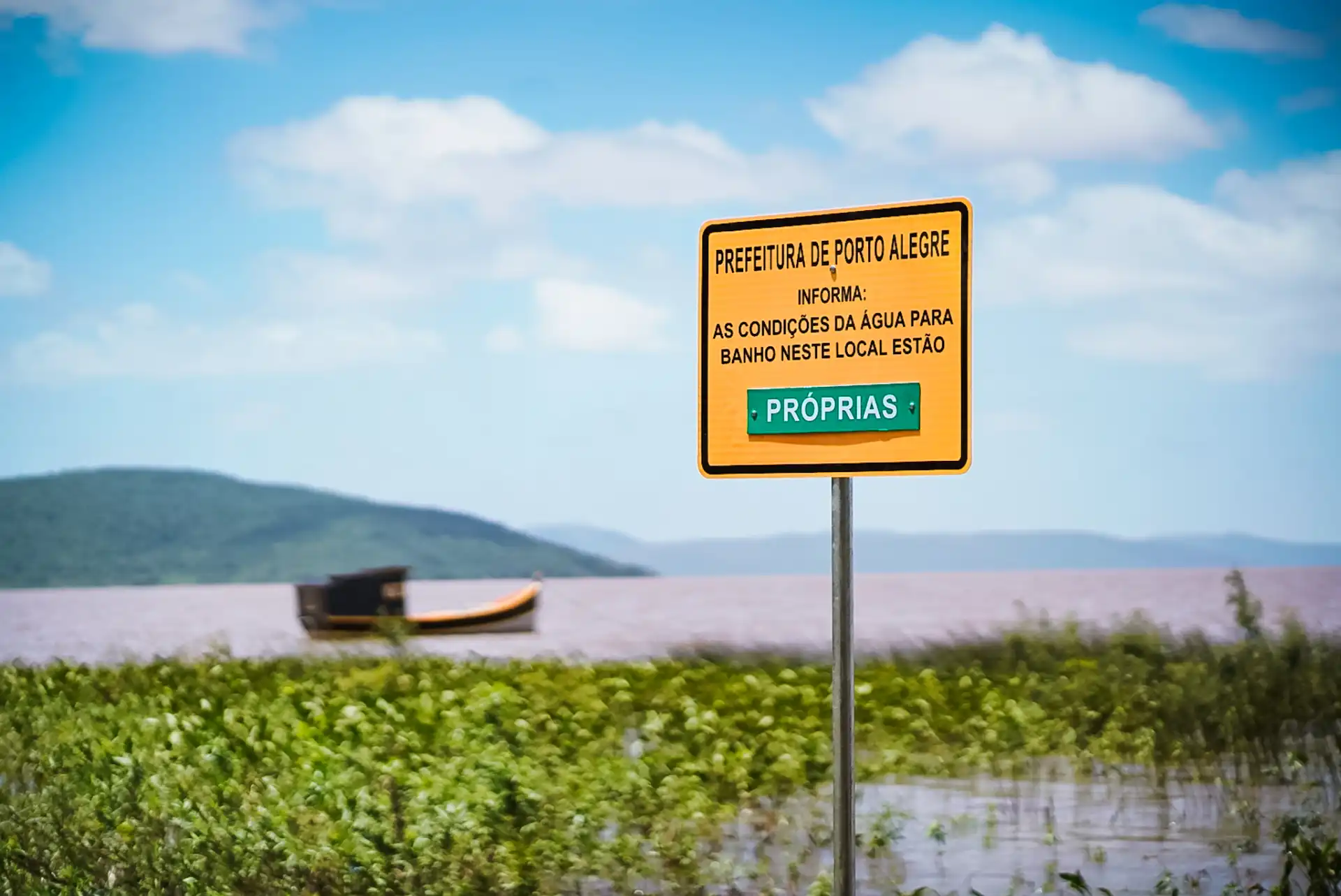 Placa da Prefeitura de Porto Alegre informa sobre as condições da água para banho na Orla do Lami, destacando que estão próprias.