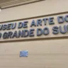 Placa de entrada do Museu de Arte do Rio Grande do Sul, destacando seu nome e placa com marca da inundação da enchente de 2024.