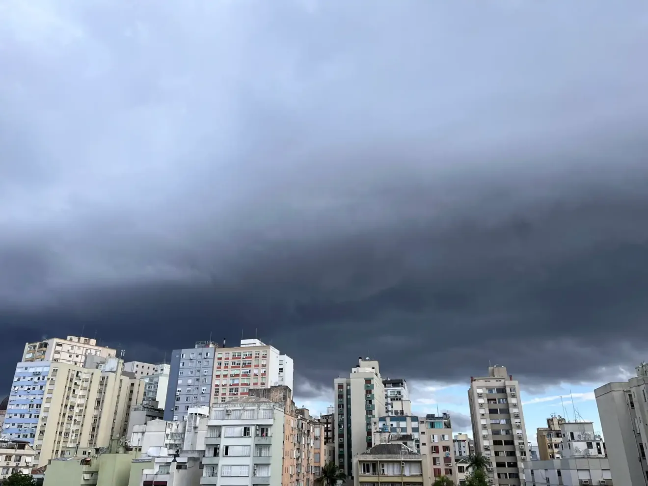 Imagem de um céu nublado sobre edifícios do Centro de Porto Alegre. As nuvens escuras ameaçam chuva.