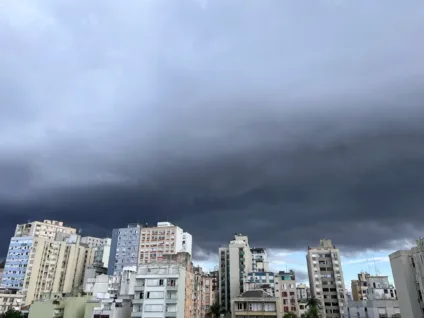 Imagem de um céu nublado sobre edifícios do Centro de Porto Alegre. As nuvens escuras ameaçam chuva.