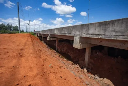 Dique Rio Branco em Canoas, mostrado em perspectiva com vista do solo e estrutura elevada. Estrada e vegetação ao fundo em um dia claro.