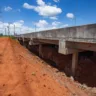 Dique Rio Branco em Canoas, mostrado em perspectiva com vista do solo e estrutura elevada. Estrada e vegetação ao fundo em um dia claro.