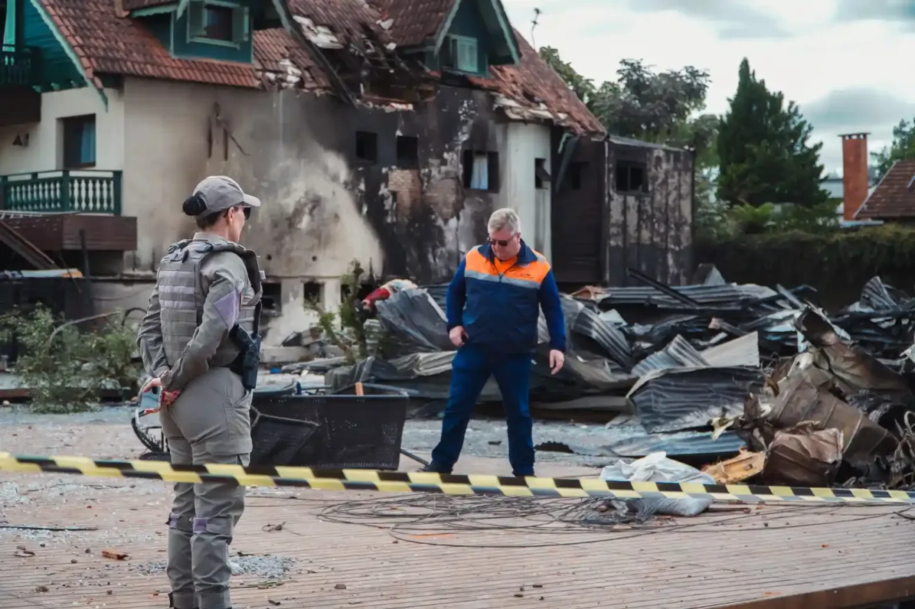 Imagem do local do acidente aéreo em Gramado, mostrando os destroços e as autoridades trabalhando na cena.