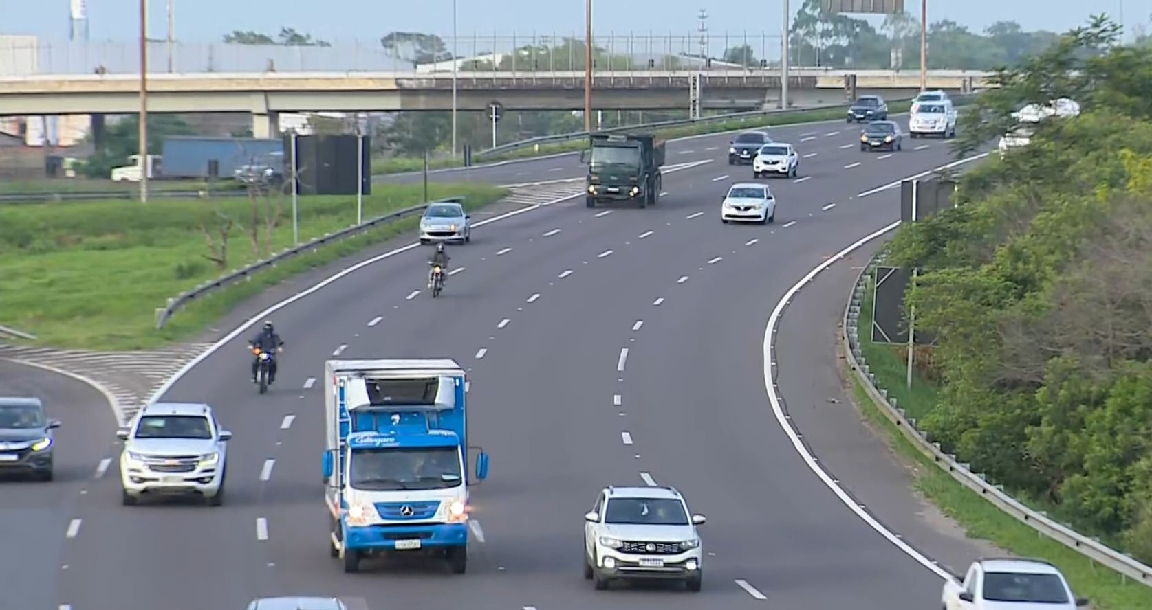 Trânsito intenso na FreeWay com veículos, caminhões e motocicletas.