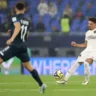 Jogador do Botafogo em ação durante partida, vestindo uniforme branco, em confronto contra o Pachuca com camisa escura.