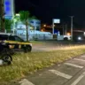 Cena noturna com viatura da PRF e uma motocicleta acidentada em rodovia.