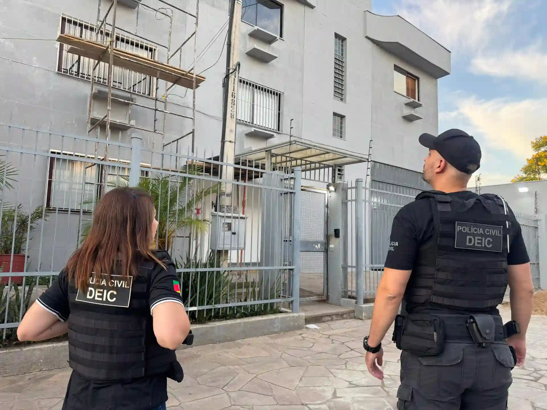 Agentes da Polícia Civil da DEIC durante a Operação False Care, observando um edifício em cumprimento de mandado.