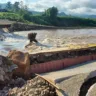 Imagem da ponte danificada por inundação, em Feliz, no Vale do Caí. A cena destaca a erosão e a destruição causada pela água.