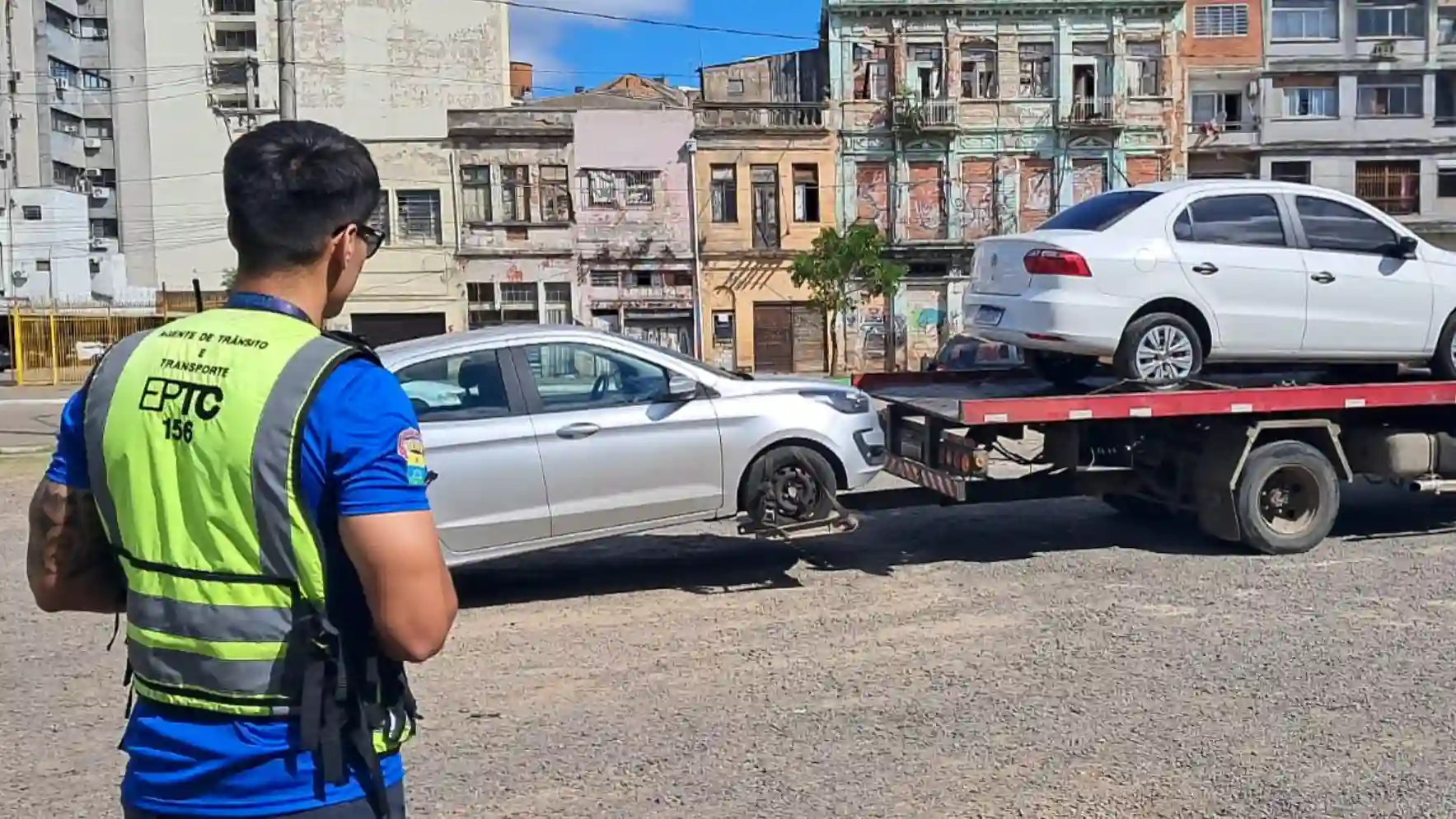 Imagem mostrando um agente de trânsito da EPTC supervisionando a remoção de veículos.