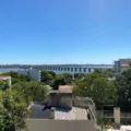 Vista panor&acirc;mica do rio Uruguai com a Ponte Internacional e pr&eacute;dios ao fundo em um dia ensolarado.