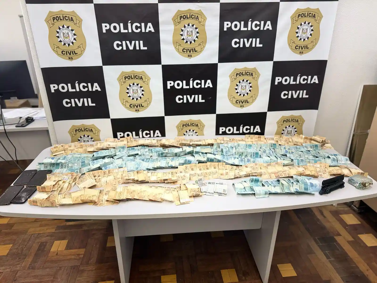 Apreensão de R$25.000,00, celulares e maconha pela Polícia Civil.