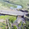 Vista aérea da Barragem do Arroio Taquarembó em Dom Pedrito, destacando a vegetação ao redor e a área da barragem.