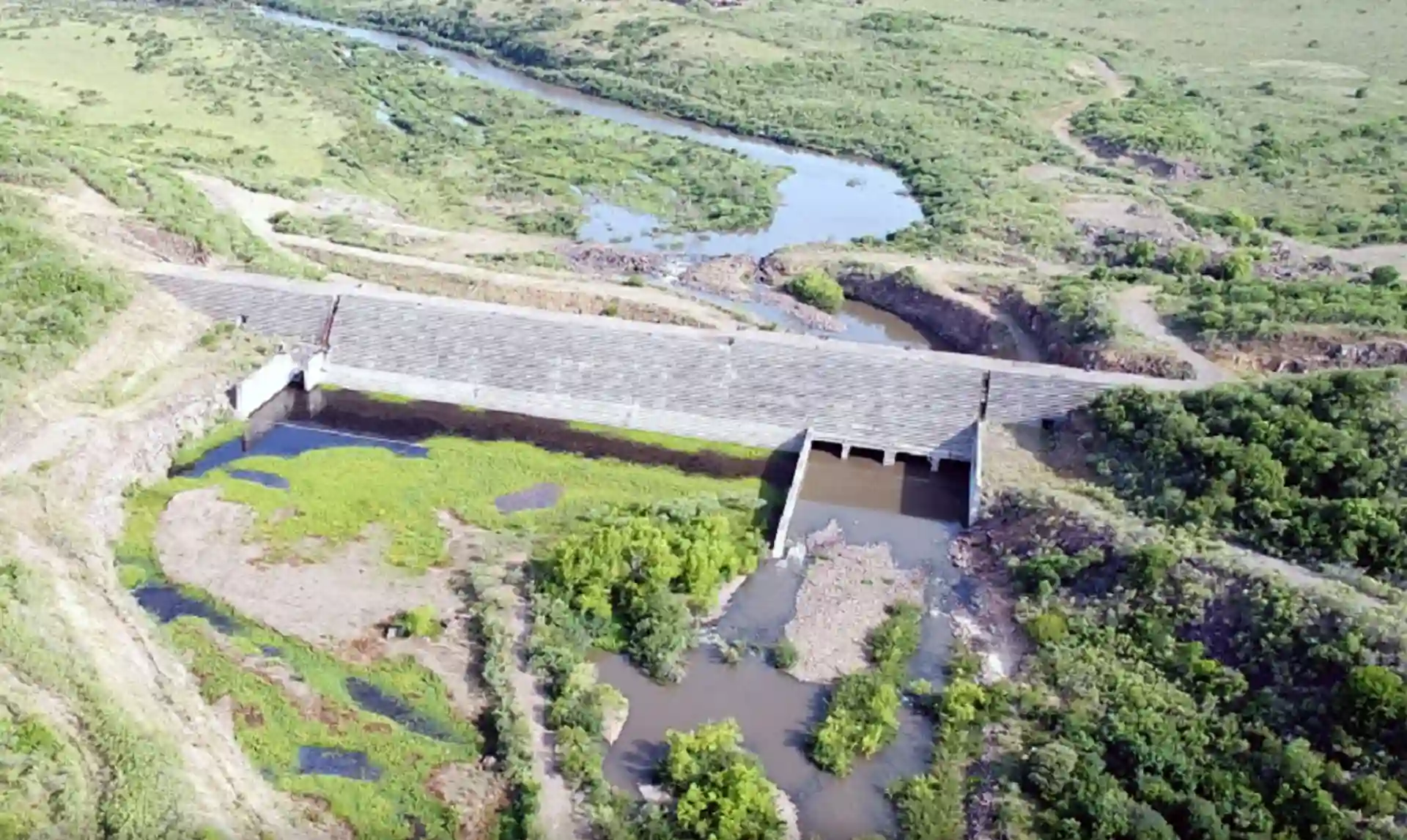 Vista aérea da Barragem do Arroio Taquarembó em Dom Pedrito, destacando a vegetação ao redor e a área da barragem.