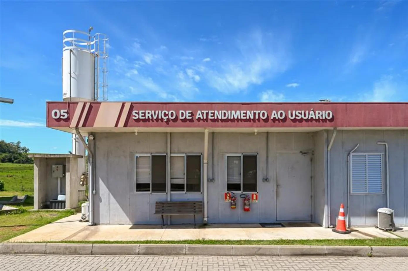 Imagem do serviço de atendimento ao usuário da CCR ViaSul, localizado em uma base de apoio. A estrutura é simples, com uma fachada clara e sinalização visível.