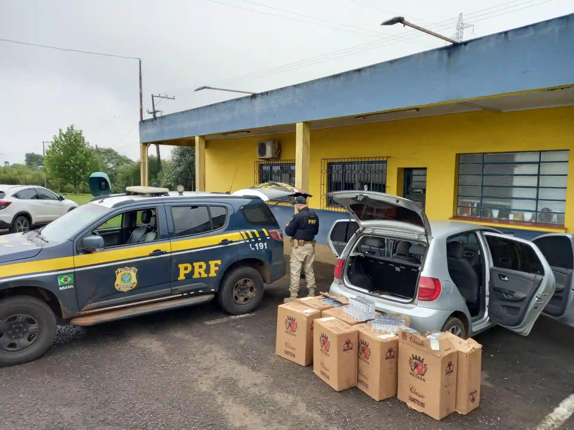 PRF realiza ação em Vacaria, apreendendo mais de 5 mil maços de cigarros contrabandeados como parte da repressão ao tráfico. Veículos da PRF estão na cena.