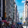 Vista da Rua dos Andradas no Centro Histórico de Porto Alegre, mostrando o movimento de pessoas e edificações históricas.