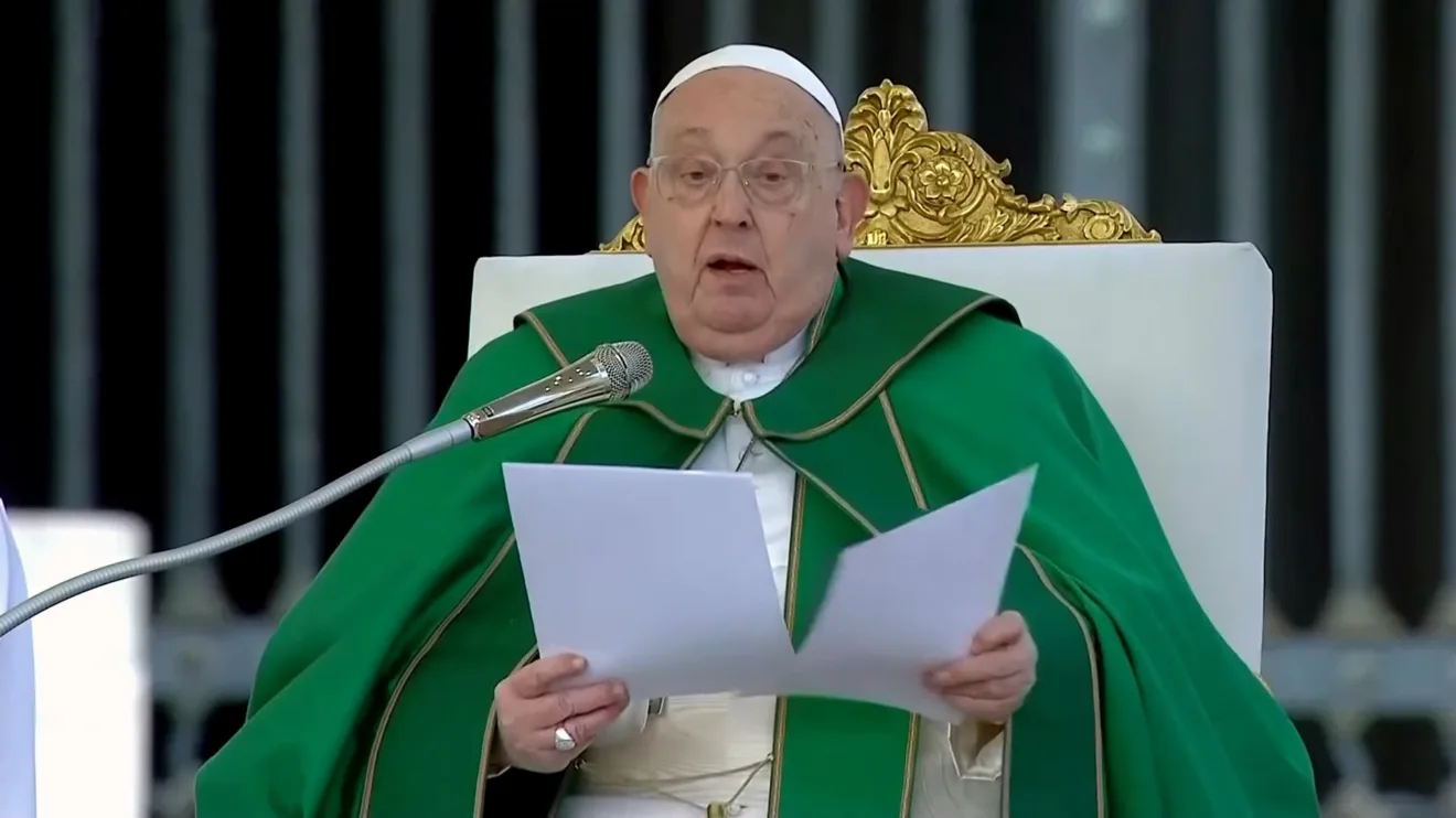 Papa Francisco lendo durante cerimônia do Angelus. Ele usa um manto verde e está em uma cadeira ornada, simbolizando sua posição na Igreja Católica.