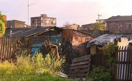 Imagem do bairro Sarandi mostrando áreas danificadas por incêndio, com estruturas de madeira queimadas e vegetação ao redor.