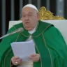 Papa Francisco lendo durante uma cerimônia. Ele usa um manto verde e está em uma cadeira ornada, simbolizando sua posição na Igreja Católica.