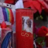 Vela com a imagem do Papa Francisco em um altar decorado com rosas e outros objetos religiosos.