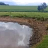 Imagem que retrata a seca em Ernestina, mostrando um açude com nível baixo de água em uma propriedade rural.