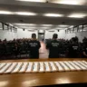 Imagem de uma reunião da Polícia Civil com diversos participantes. Agentes estão em pé em frente a uma plateia lotada