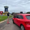 Agente da PRF fiscaliza carro vermelho durante operação do feriado do Dia do Trabalhador