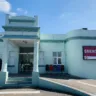 Fachada do Hospital Centenário em São Leopoldo, destacando a entrada do pronto atendimento de emergência, com céu azul ao fundo.