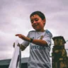 Foto de Darcy Lawrey: https://www.pexels.com/pt-br/foto/garoto-com-camisa-branca-e-azul-fly-emirates-jersey-segurando-na-escada-barra-de-apoio-sob-o-ceu-cinza-913501/