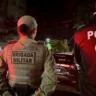 Imagem de policiais militares e civis em operação noturna na rua, com viaturas e iluminação urbana.