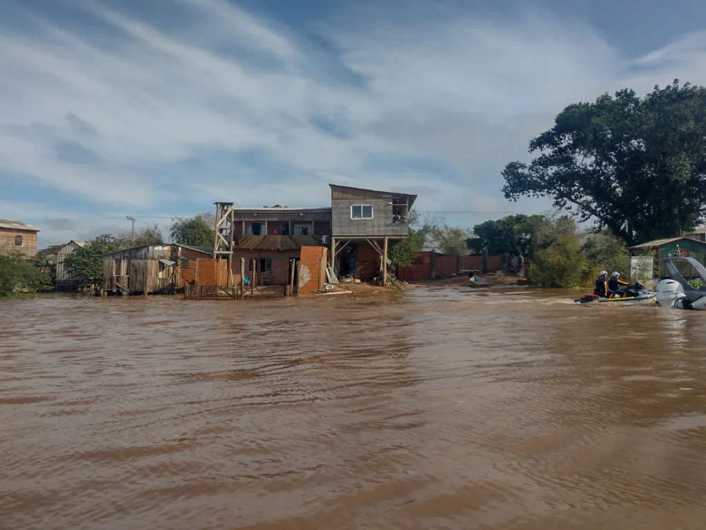 Cheia do Guaíba atingindo o bairro Arquipélago em Porto Alegre, com casas afetadas pela enchente e ruas alagadas