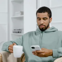 <a href="https://www.pexels.com/photo/a-man-in-gray-hoodie-holding-a-cup-of-coffee-while-using-a-smartphone-8217363/" target="_blank" rel="noreferrer noopener"><strong>Photo by MART  PRODUCTION, Pexels</strong></a>